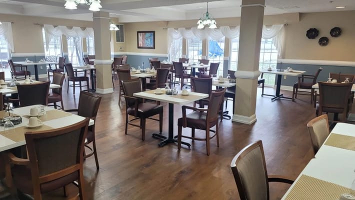 Dining area with tables and chairs in South Hills Senior Living facility.