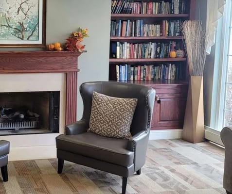 Comfortable lounge seating with a fireplace and bookshelf