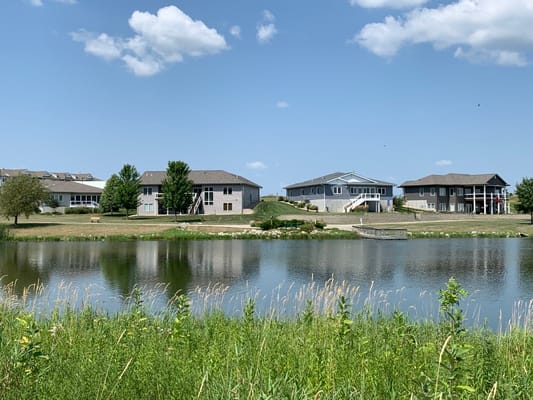 View of facility buildings by a serene pond
