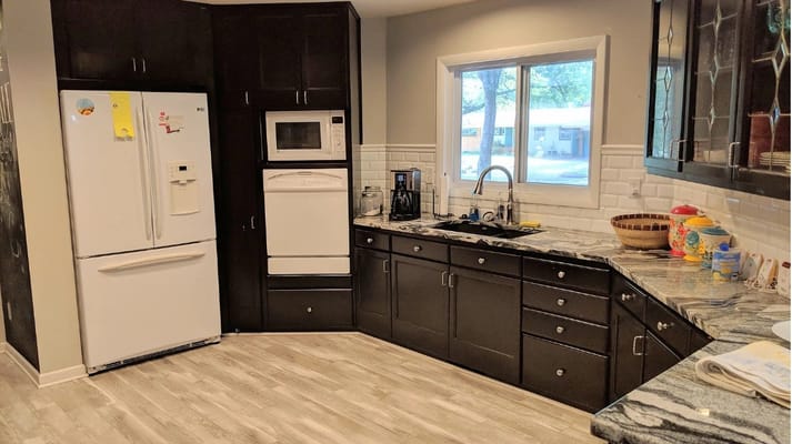 Modern kitchen with white appliances and dark cabinets