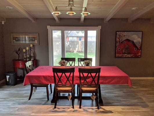 Interior view of a dining area with a red tablecloth and chairs.