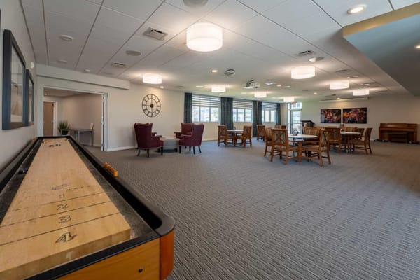Spacious common area featuring seating and shuffleboard table