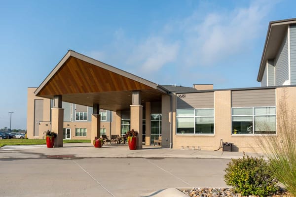 Front entrance of Immanuel Graceview Courtyard with a wooden canopy and red planters.