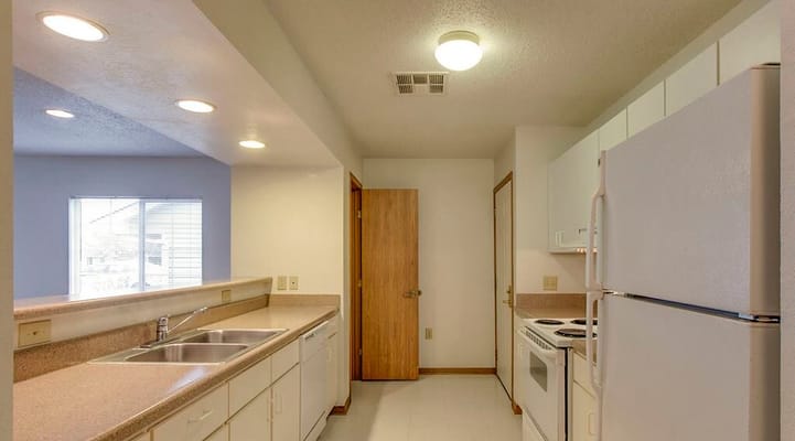 Bright kitchen with white appliances and countertops