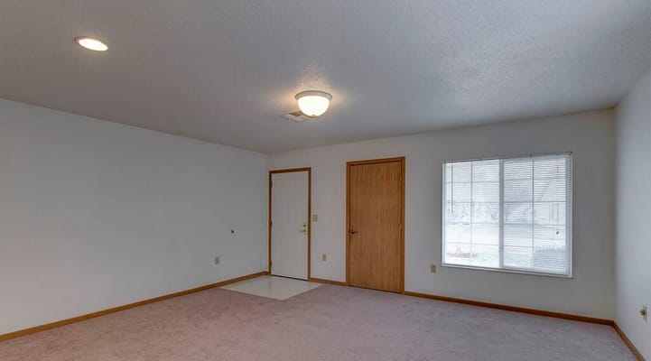 Empty living room with a door and a window