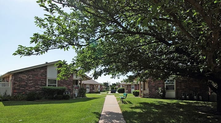 Pathway lined with greenery and residential buildings at Prairie Villa.