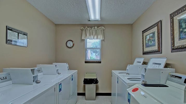 Bright laundry room with washing machines and a window.