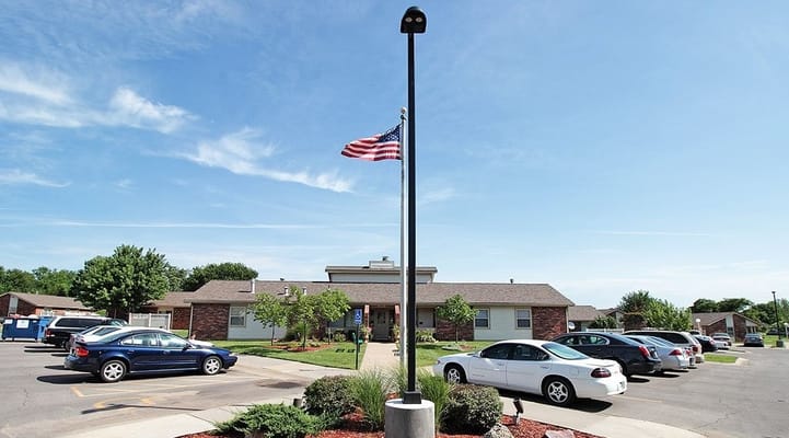 Main entrance view with American flag and parked cars