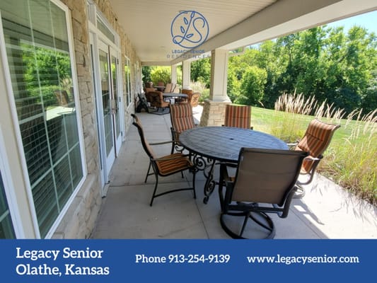 Outdoor seating area with a round table and chairs at Legacy Senior Residences.