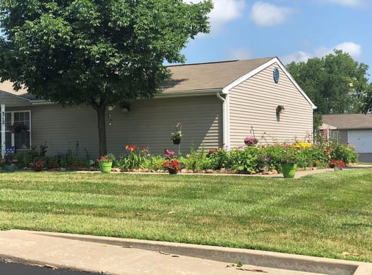 Exterior view of a cottage with flower beds