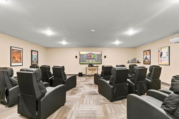 Bright common area with reclining chairs and a movie screen