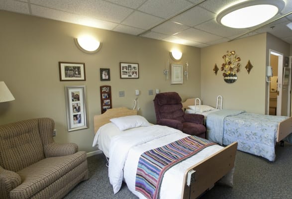 A cozy resident room with two beds and seating
