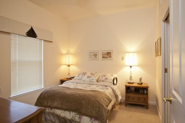 Cozy private bedroom with floral bedding and lamps