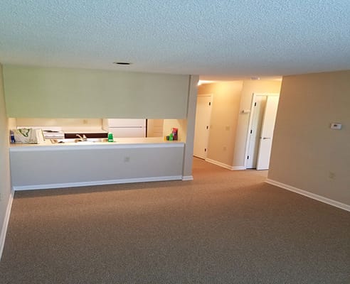 Spacious living room area with a view of the kitchen
