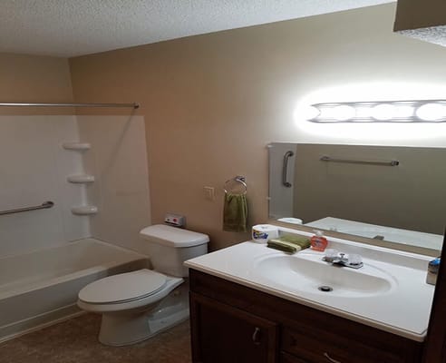 A well-equipped bathroom featuring a bathtub, toilet, and sink.