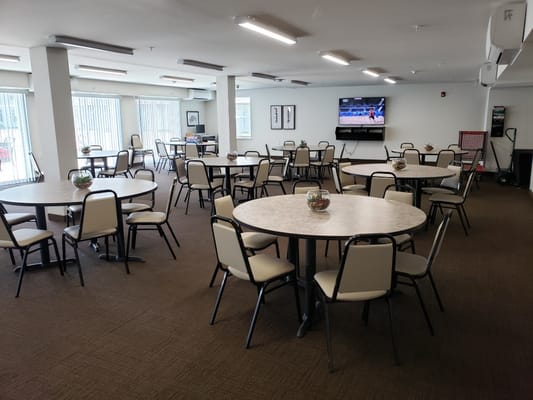 Common area with tables and chairs set up for activities