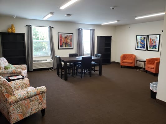 Common area with seating and tables in a senior apartment