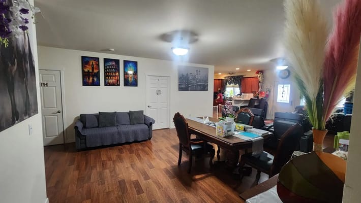 Spacious common area with seating and dining table in a senior living facility