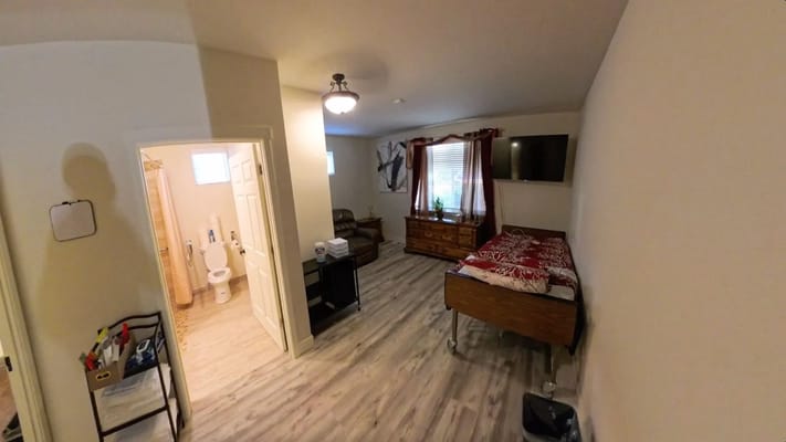 Cozy private room with bed, seating area, and bathroom access.