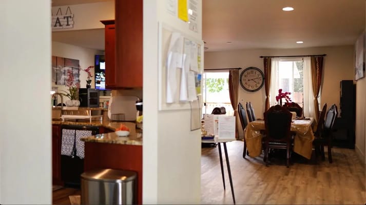 View of the dining area from the kitchen in a senior living facility.