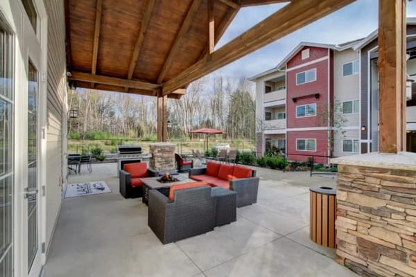 Outdoor lounge area with seating and a fire pit at LARC at Olympia.