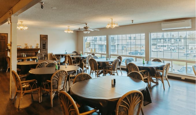 Well-lit dining area with round tables and chairs