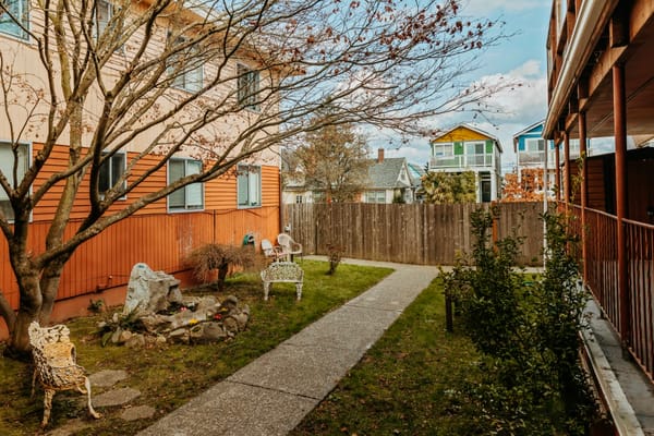 Serene garden path with decorative chairs and greenery at 6th Avenue Senior Living