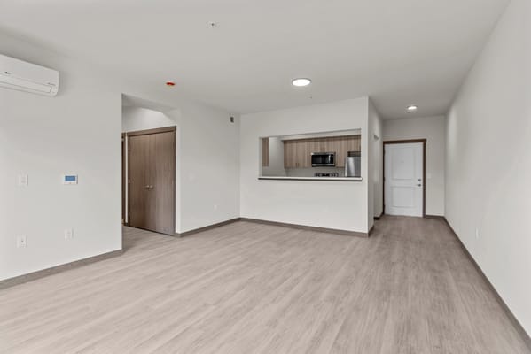 A modern, spacious living room with an open kitchen.