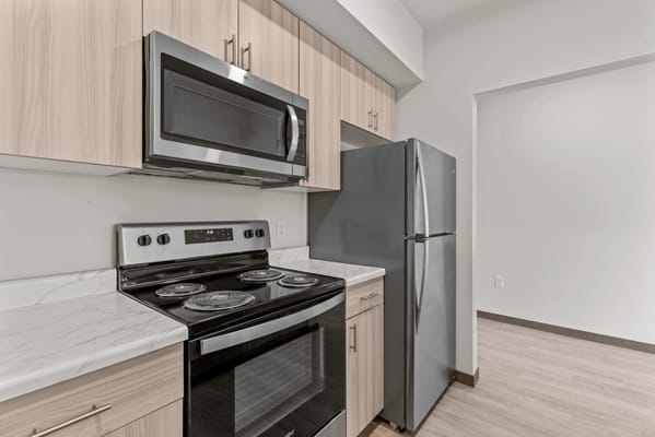 A modern kitchen with stainless steel appliances and wooden cabinetry