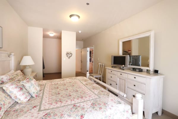Bright and inviting bedroom with floral bedding and a dresser