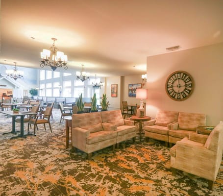 Cozy lounge area with seating and a clock.
