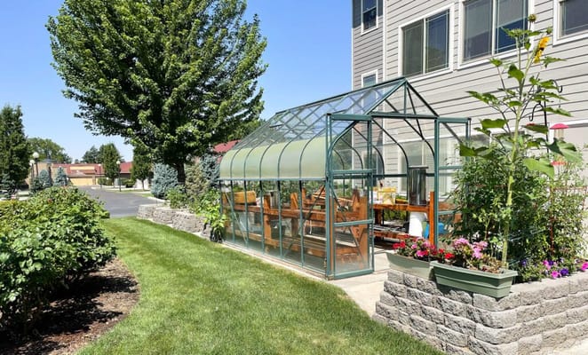 Glass greenhouse surrounded by landscaping