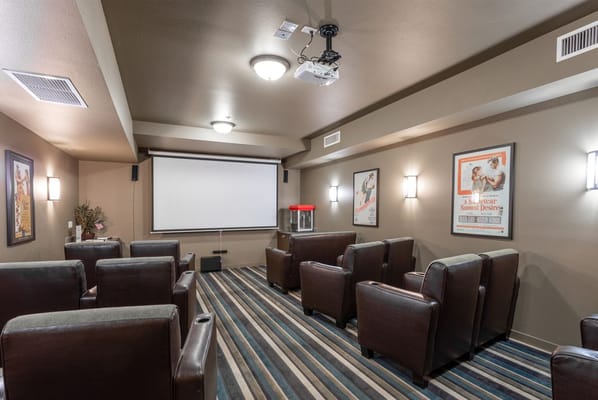 Cozy movie theater space with comfortable seating and projector