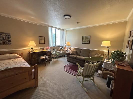 Comfortable resident room with bed, sofa, and decor