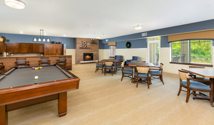 Bright common area with a pool table and lounge seating