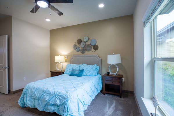 Brightly decorated resident room with a bed and lamps