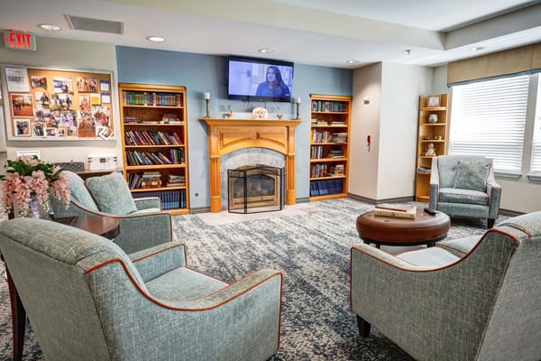 Comfortable living room with chairs, a fireplace, and bookshelves