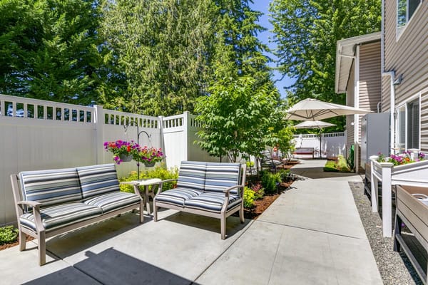 Outdoor seating area with striped chairs and potted plants at The Gardens at Marysville