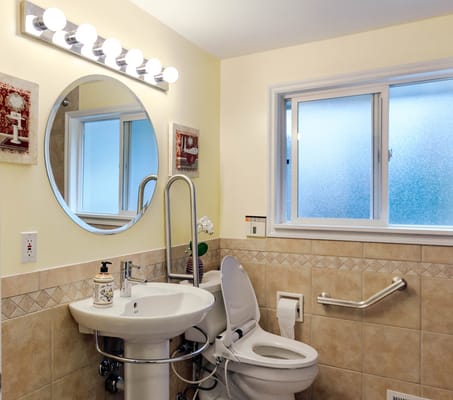 Bathroom with a sink, toilet, mirror, and window