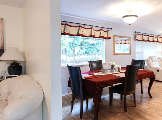 Dining room with a table and chairs, surrounded by large windows.