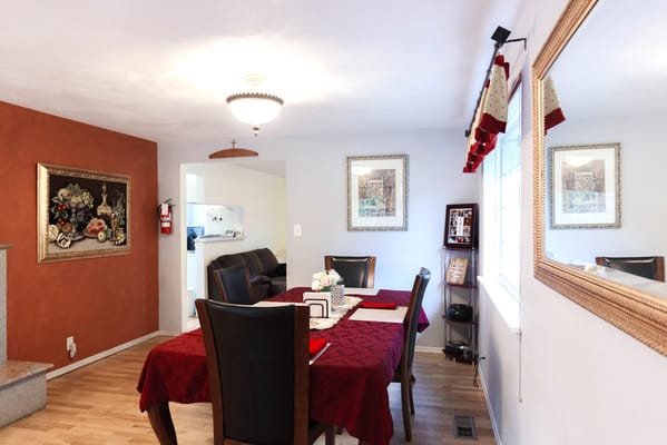 Cozy dining area with a red table cloth and decorative wall art