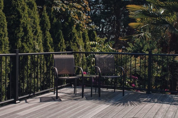 Two chairs on a patio surrounded by greenery
