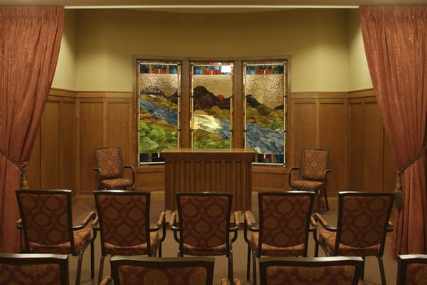 Interior view of a serene and inviting chapel with stained glass windows