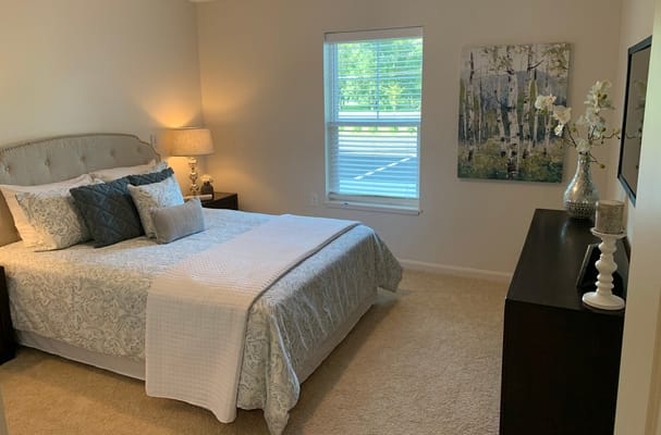 Well-decorated bedroom with a bed, lamp, and artwork