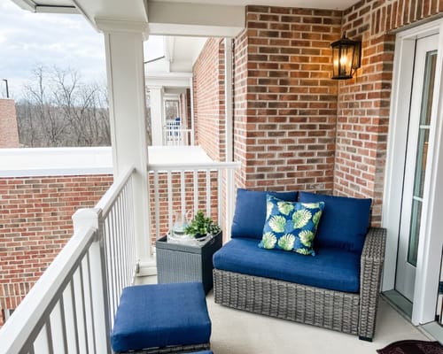 Comfortable blue sofa and ottoman on a balcony
