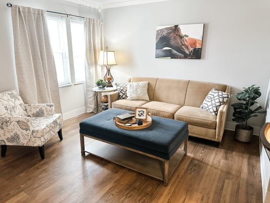 Interior view of a living room with a beige sofa, decorative pillows, and a coffee table.