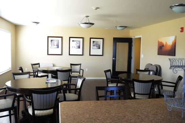 A spacious common area with round tables and chairs.