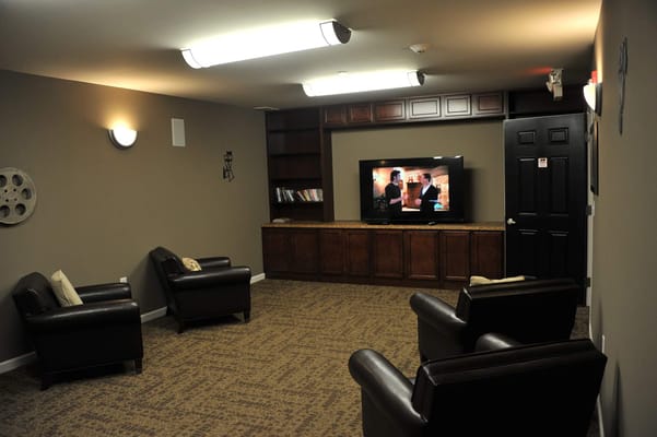 Lounge area with leather chairs and a TV in Hamburg Senior Residence.
