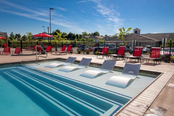 Outdoor pool area with lounge chairs and sun umbrellas