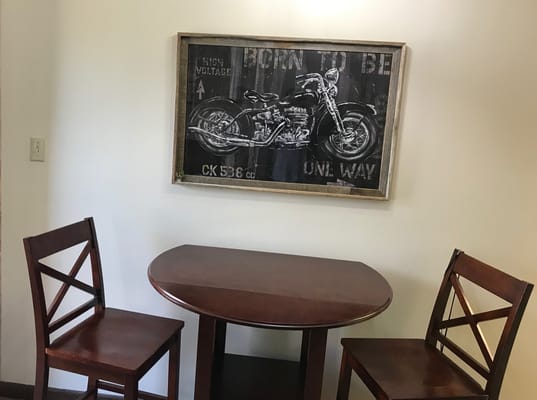 Table and chairs with motorcycle artwork on the wall
